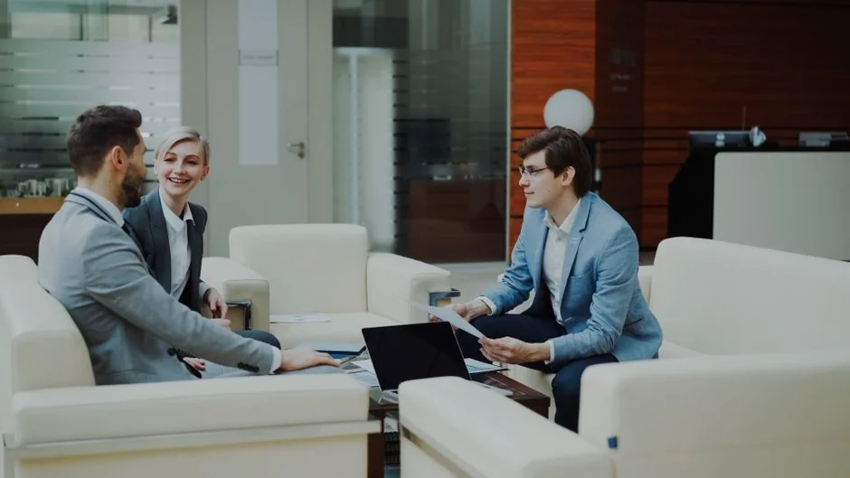 A diverse team collaborating on digital marketing strategies at a desk, using laptops and tablets.
